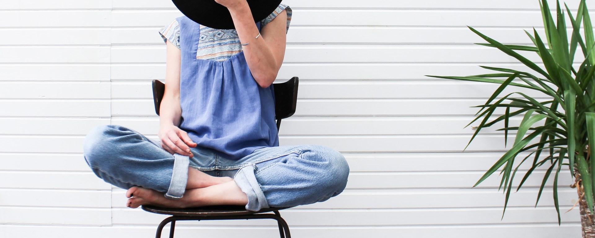 girl holding a hat in front of her face