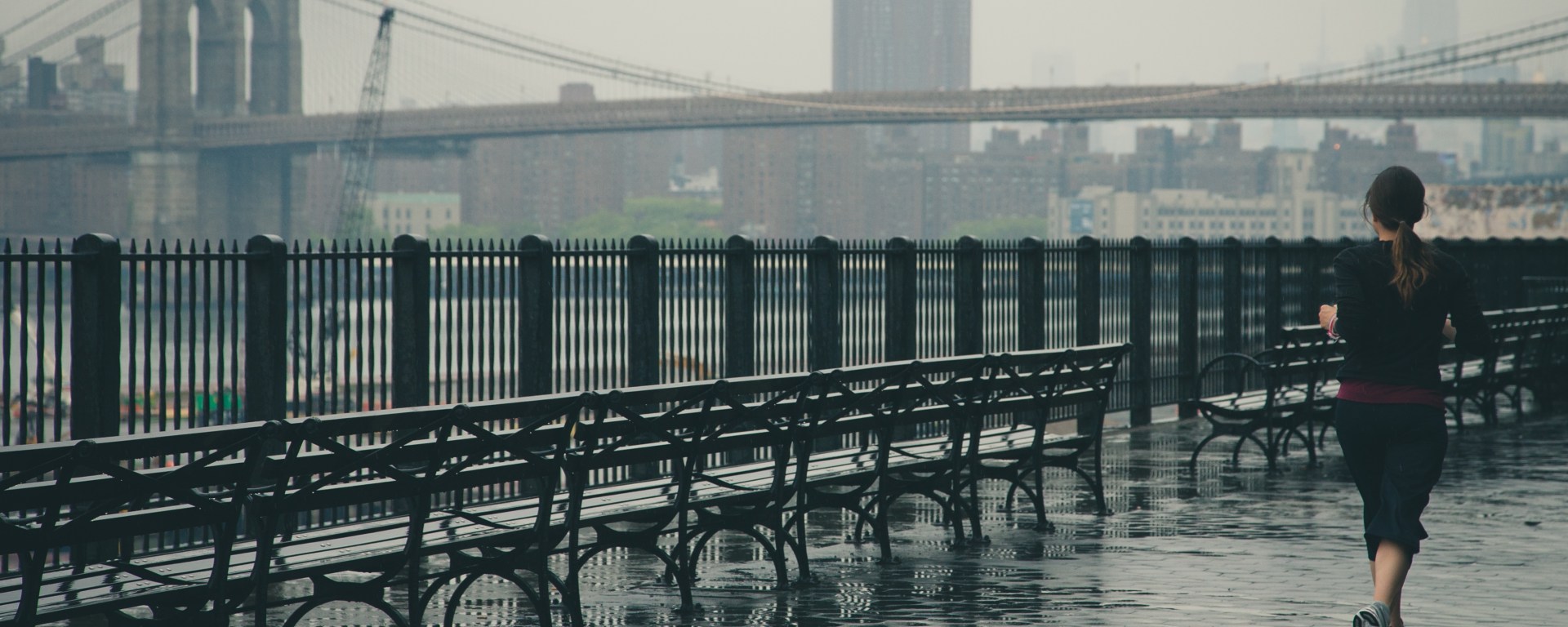 girl running outside by a bridge