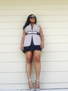 black woman wearing black leather wrap skirt, vest, and belt