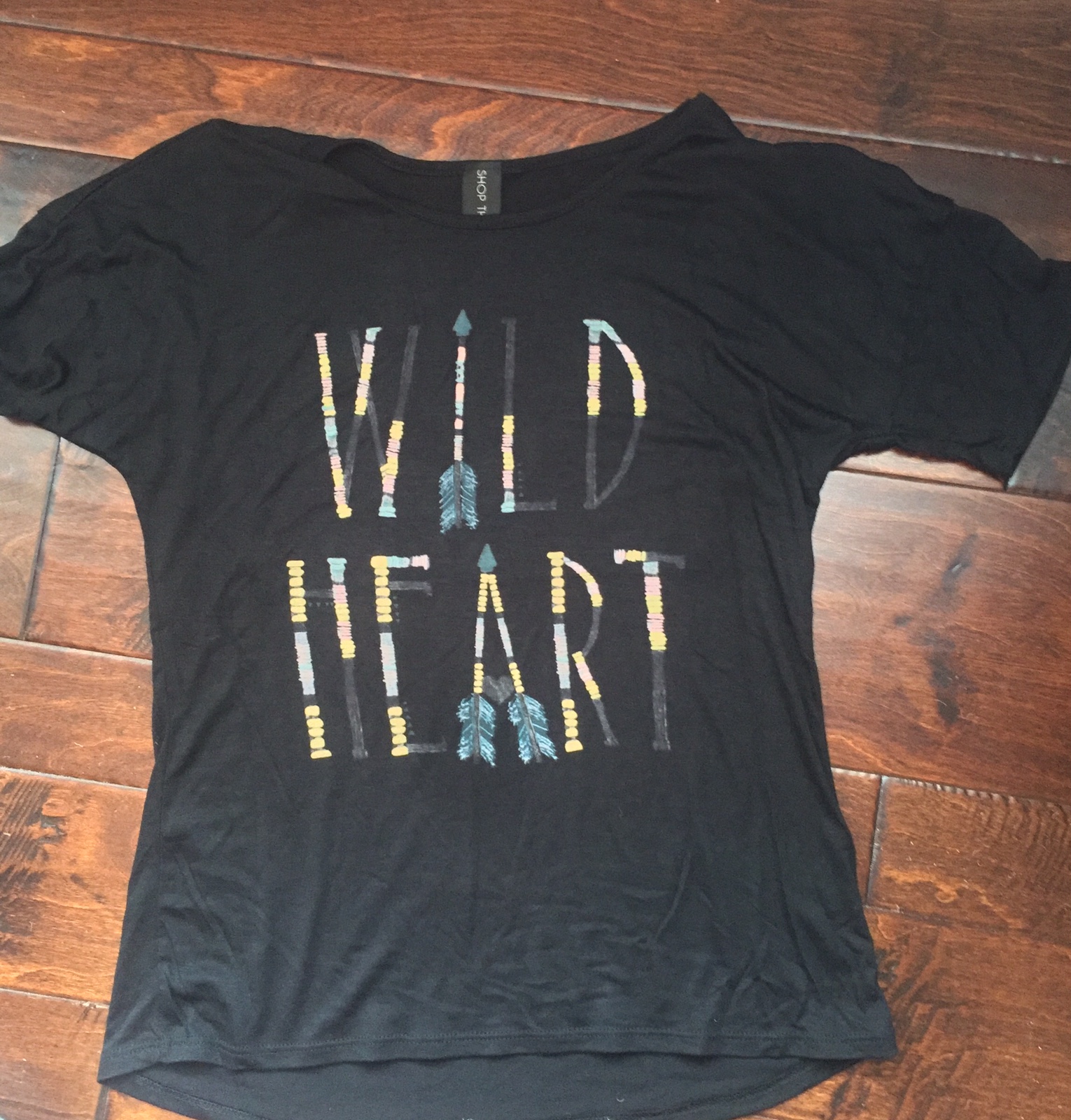 black tshirt with wild hear on the front in feathers blue labels boutique
