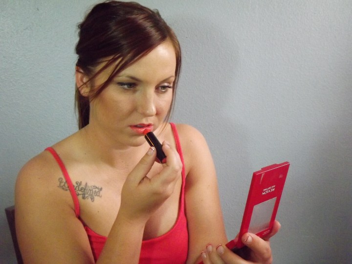 Ellie putting on bold lip color