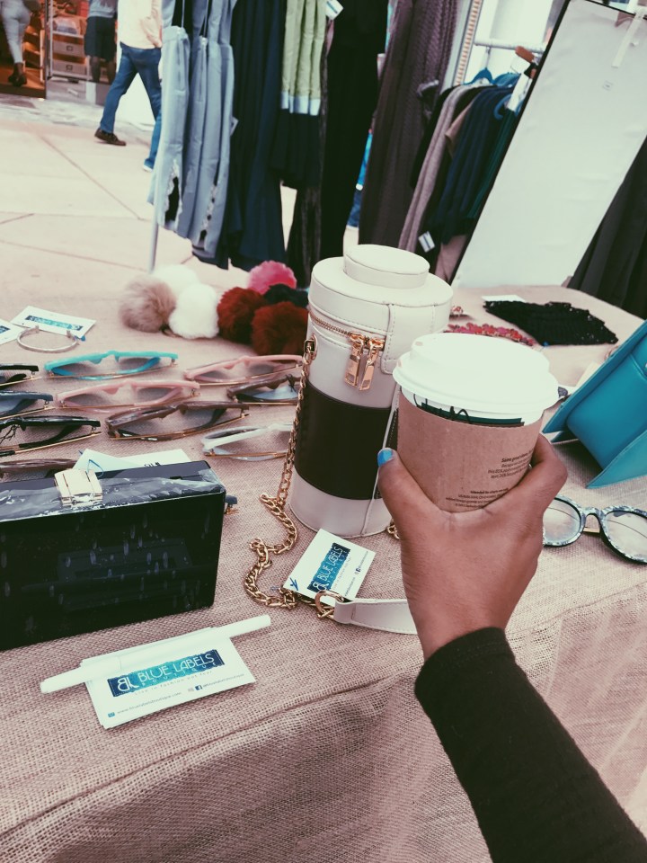 holding coffee at blue labels boutique pop up shop