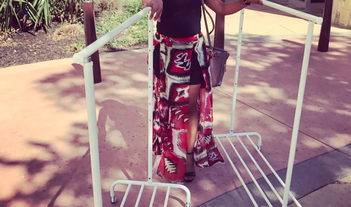 girl rolling clothing racks through mall