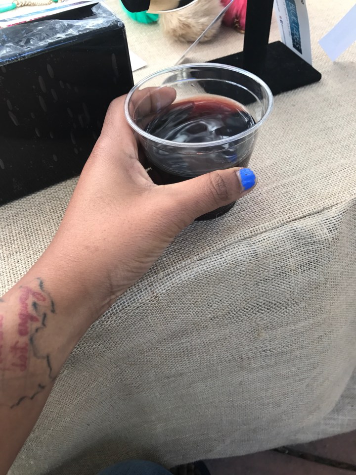 blue labels boutique owner holding a glass of wine