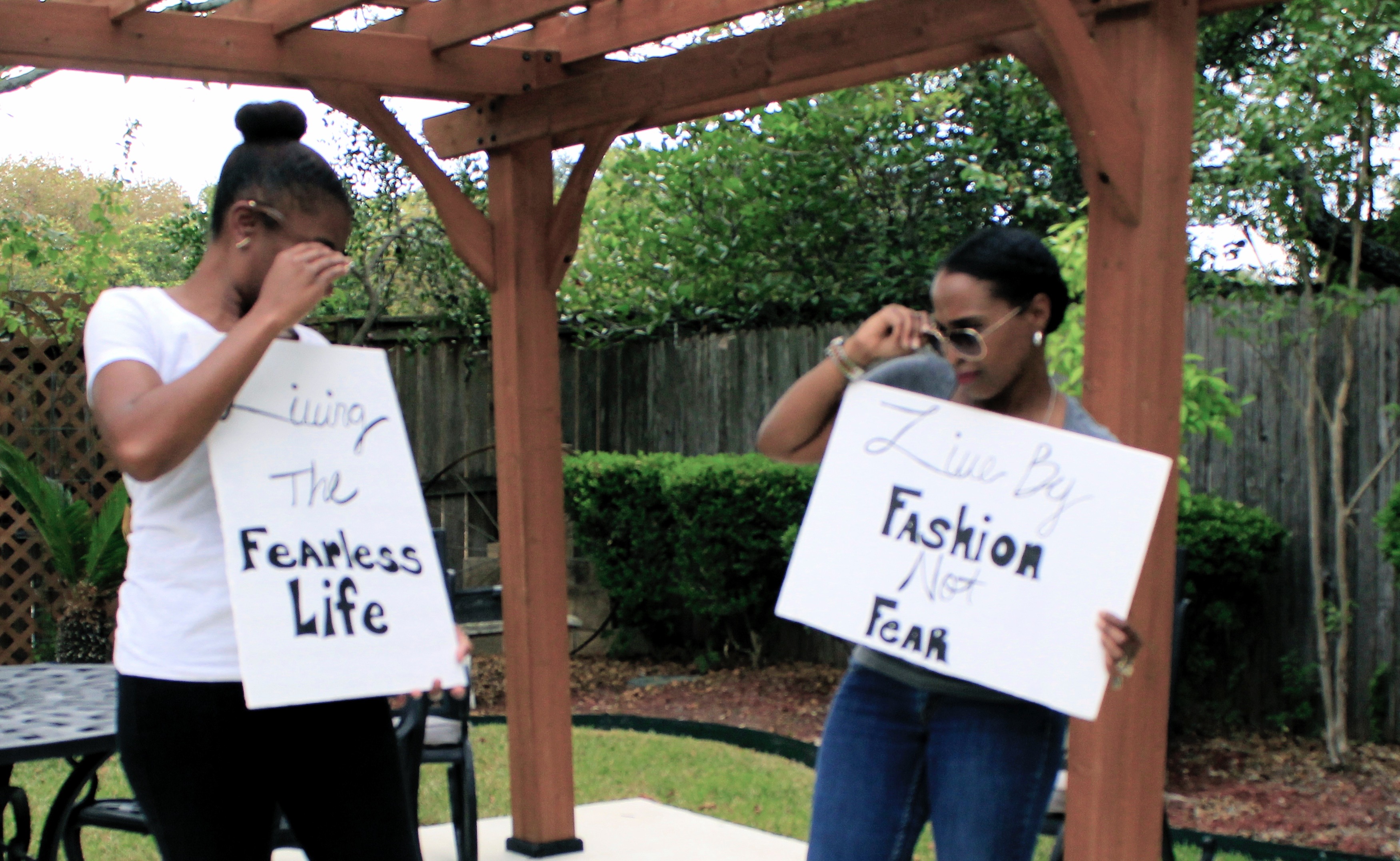 image of two women holding living the fearless life signs fashion not fear