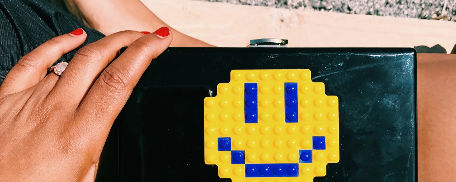 black clutch bag with smiley face blue labels boutique