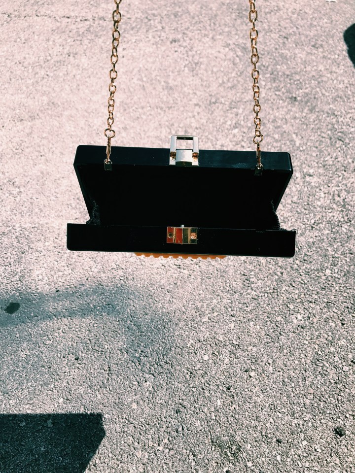 black clutch bag with smiley face blue labels boutique