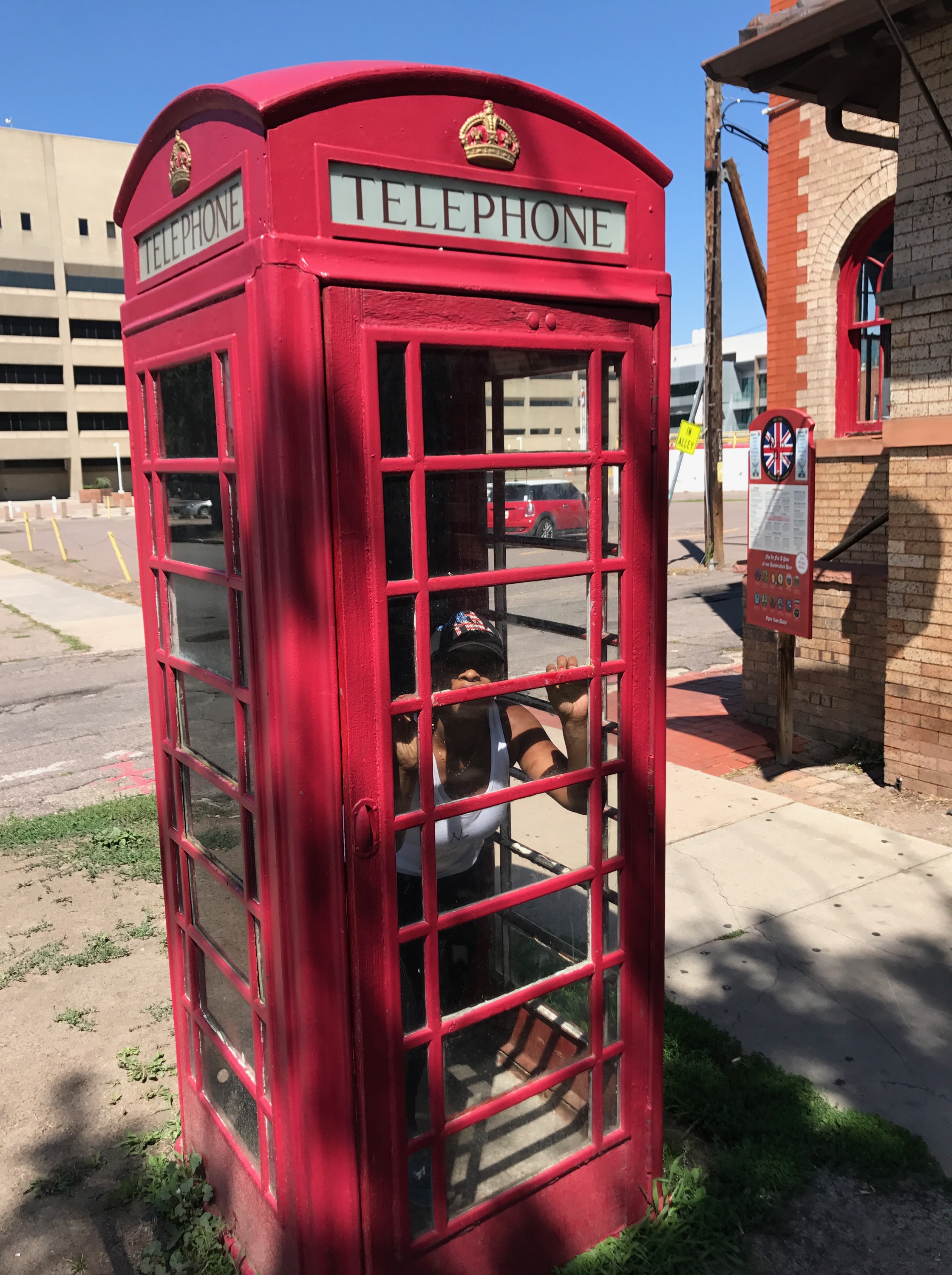 Blue Labels Boutique owner in red phone booth in denver colorado