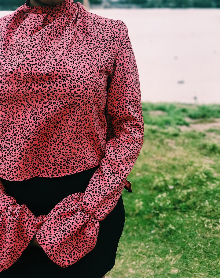 woman wearing pink black animal print blouse