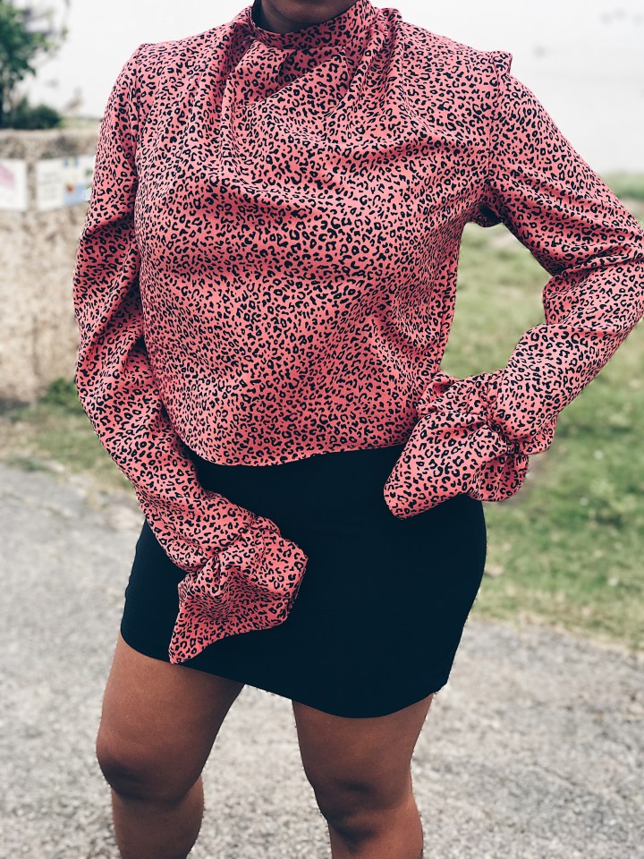 woman wearing pink black animal print blouse
