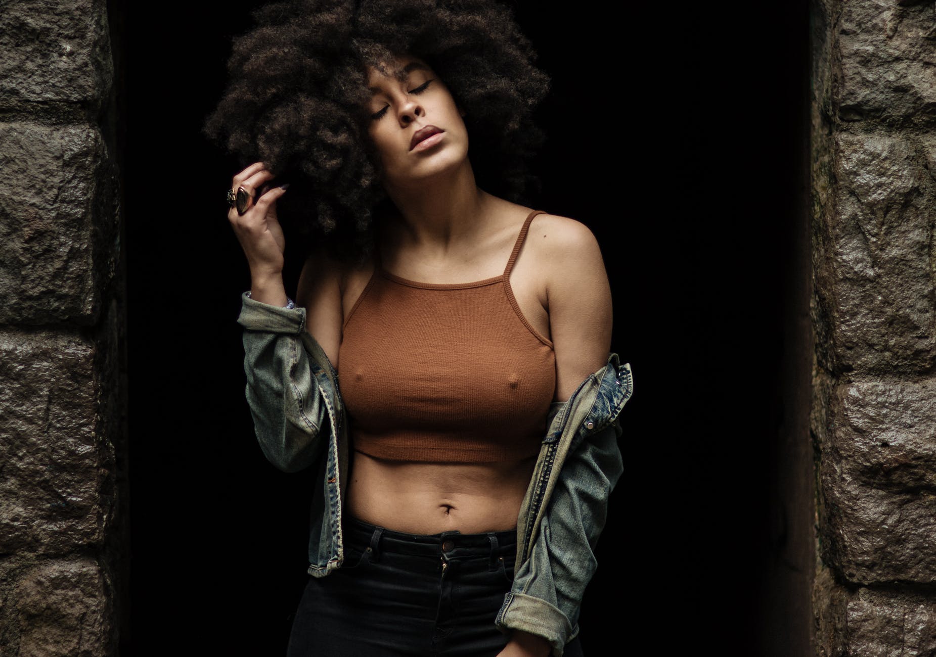woman in brown crop top standing between concrete walls