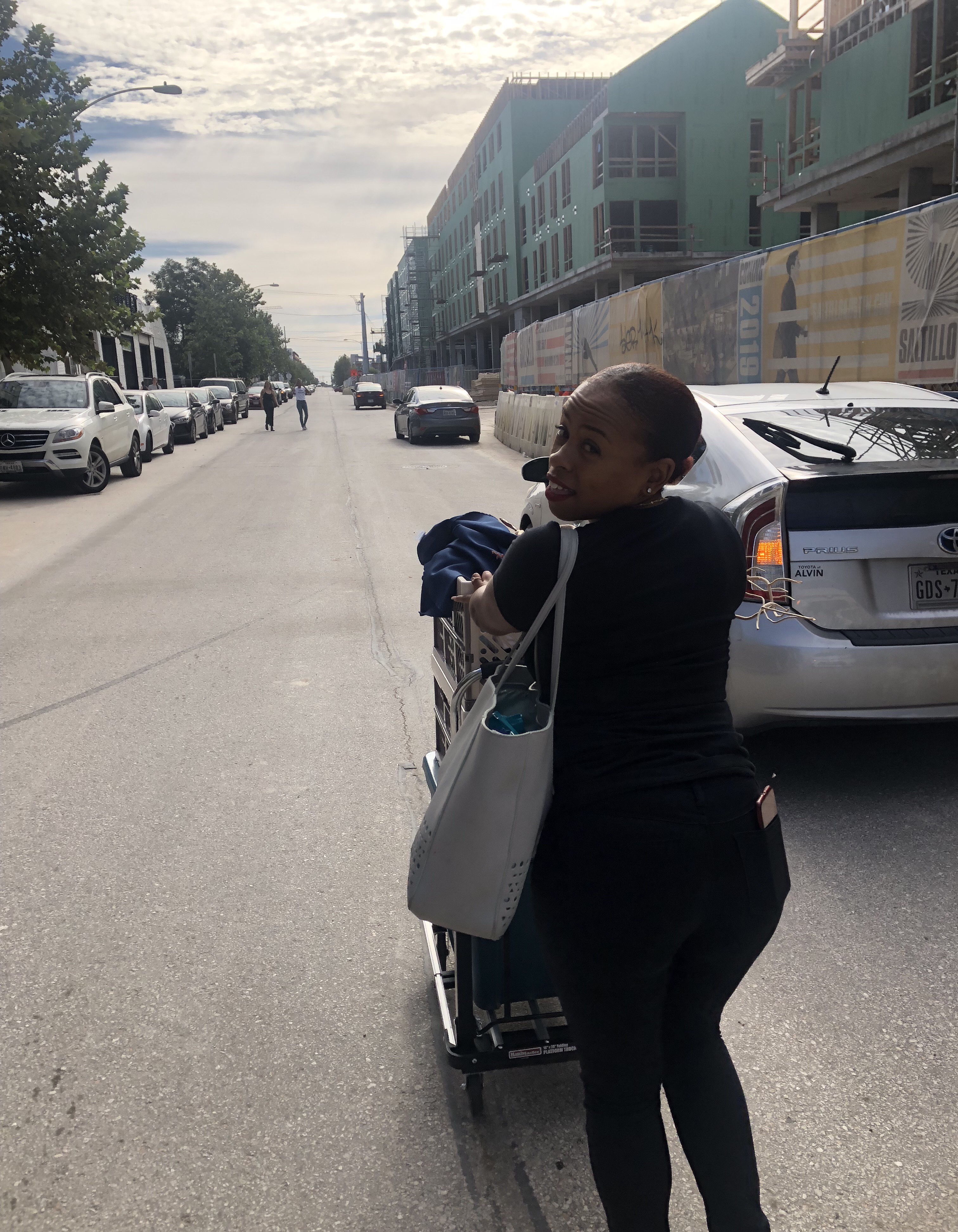 Boutique owner pushing a cart for pop up 